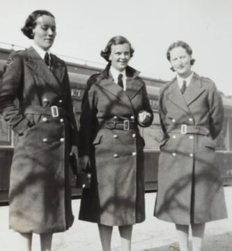 grayscale photo of three women in coats